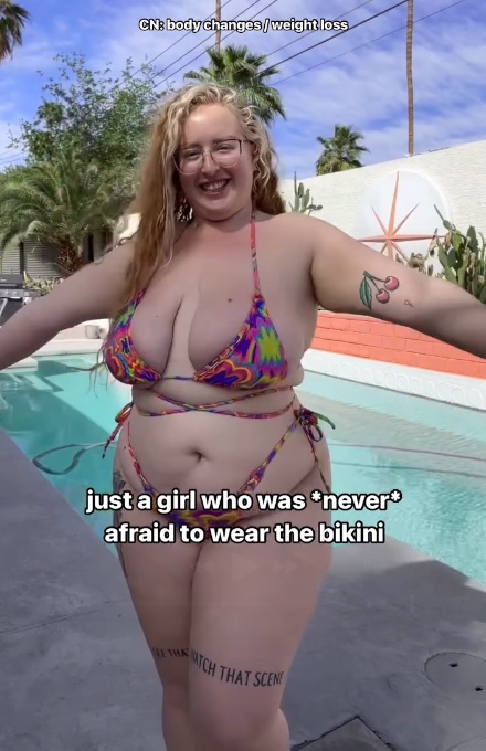 Plus-size woman in bikini by pool, expressing body positivity.