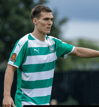 Leiws Turner in a green and white striped soccer jersey.