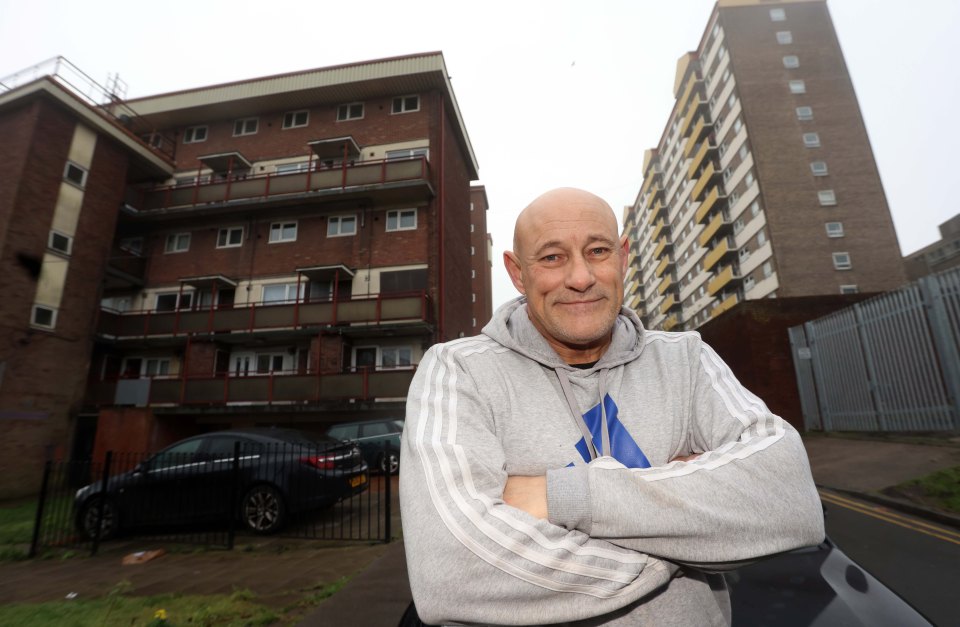 A man stands in front of apartment buildings in Pontefract, West Yorkshire.
