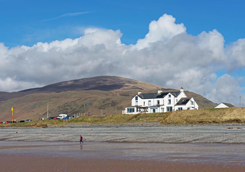 Silecroft beach, with a white building and Black Combe in the background.