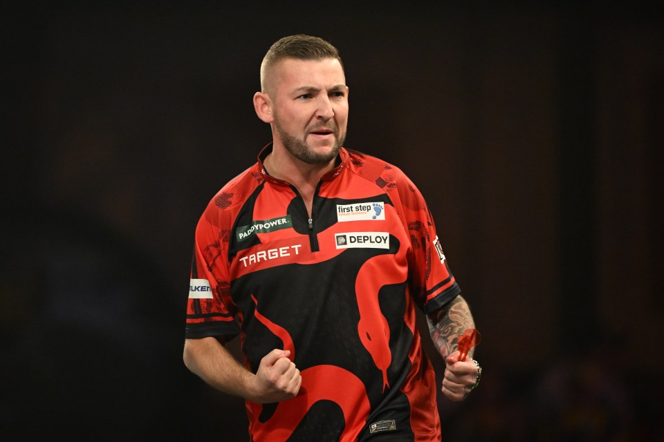 Nathan Aspinall celebrates during a darts match.