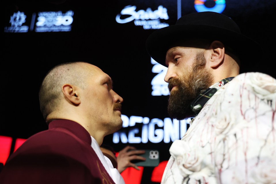 Tyson Fury and Oleksandr Usyk face off at a press conference.