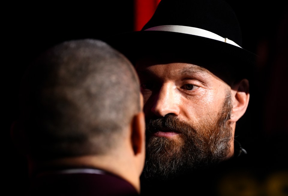 Tyson Fury and Oleksandr Usyk face off at a press conference.