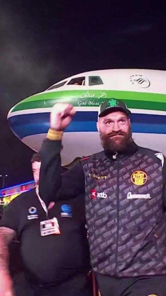 Tyson Fury celebrating near a plane.