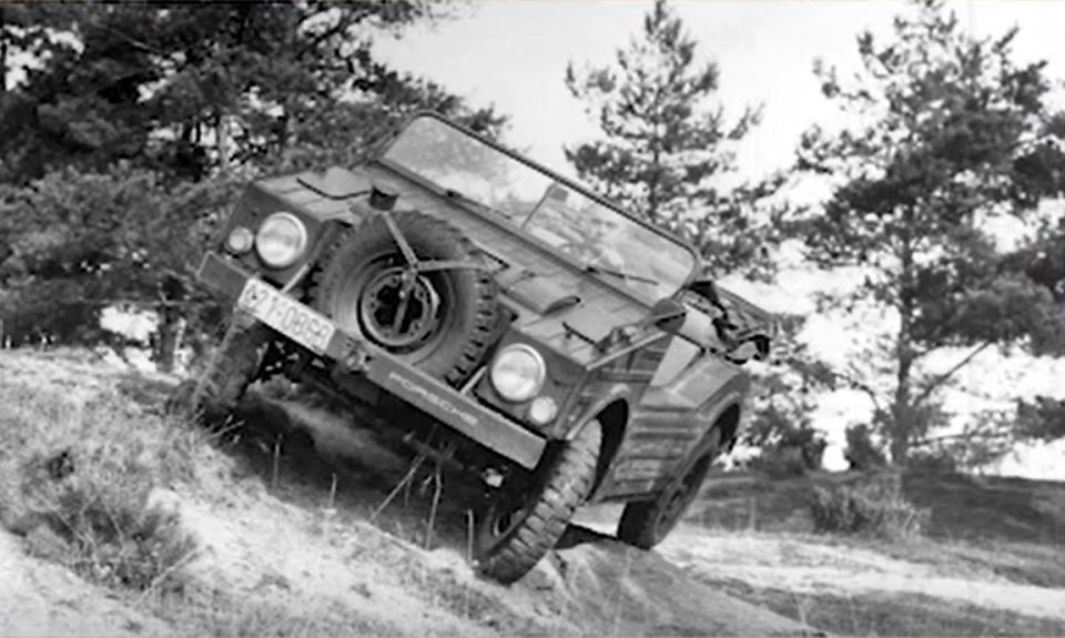 A black and white photo of a Porsche 597 Jagdwagen driving off-road.