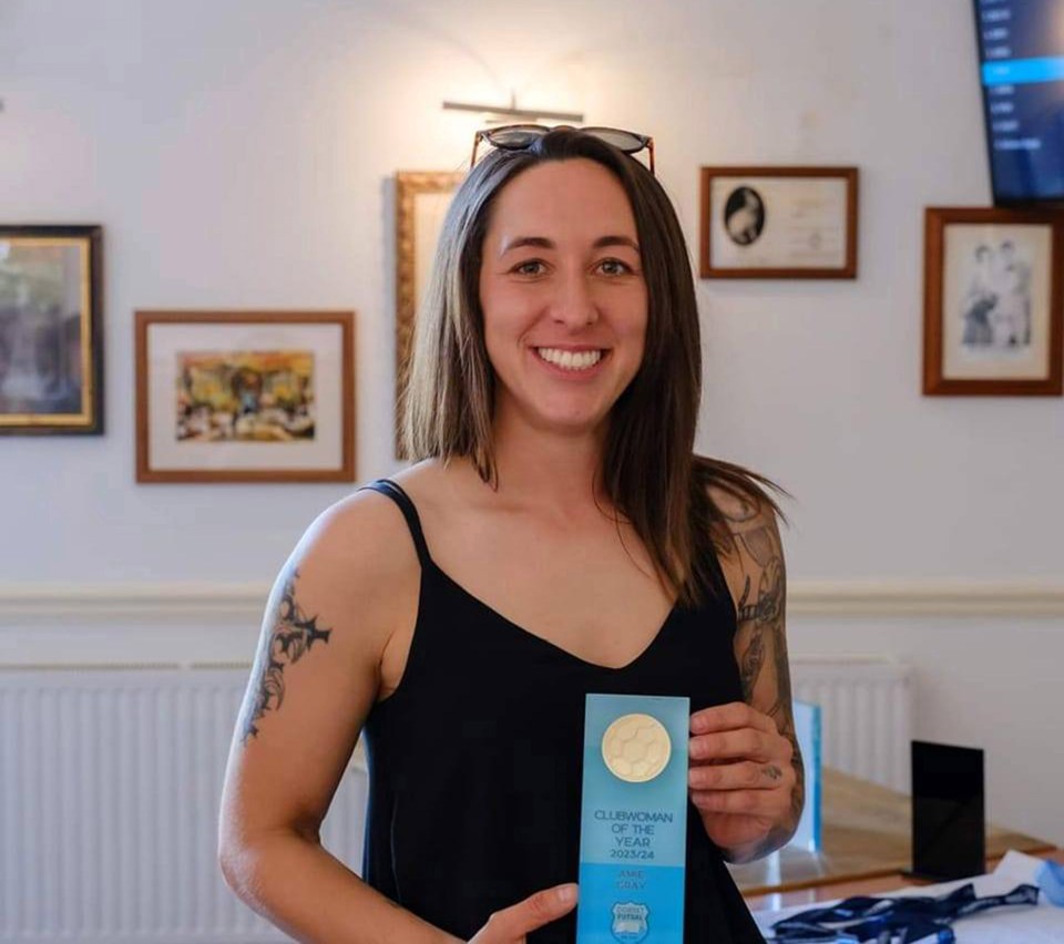 Amie Gray, a personal trainer, holding a Clubwoman of the Year award.