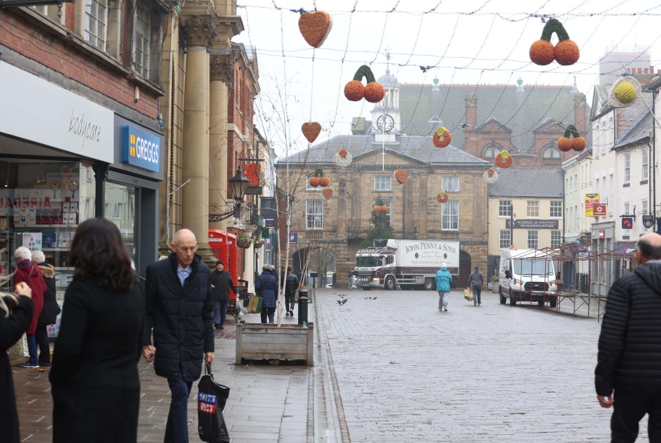 Pontefract town center street scene with shops and pedestrians.