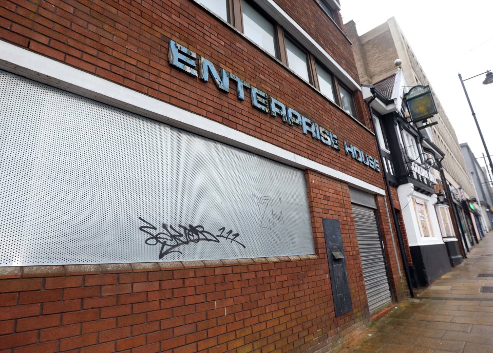 Enterprise House in Pontefract, West Yorkshire, with graffiti on a metal security screen.
