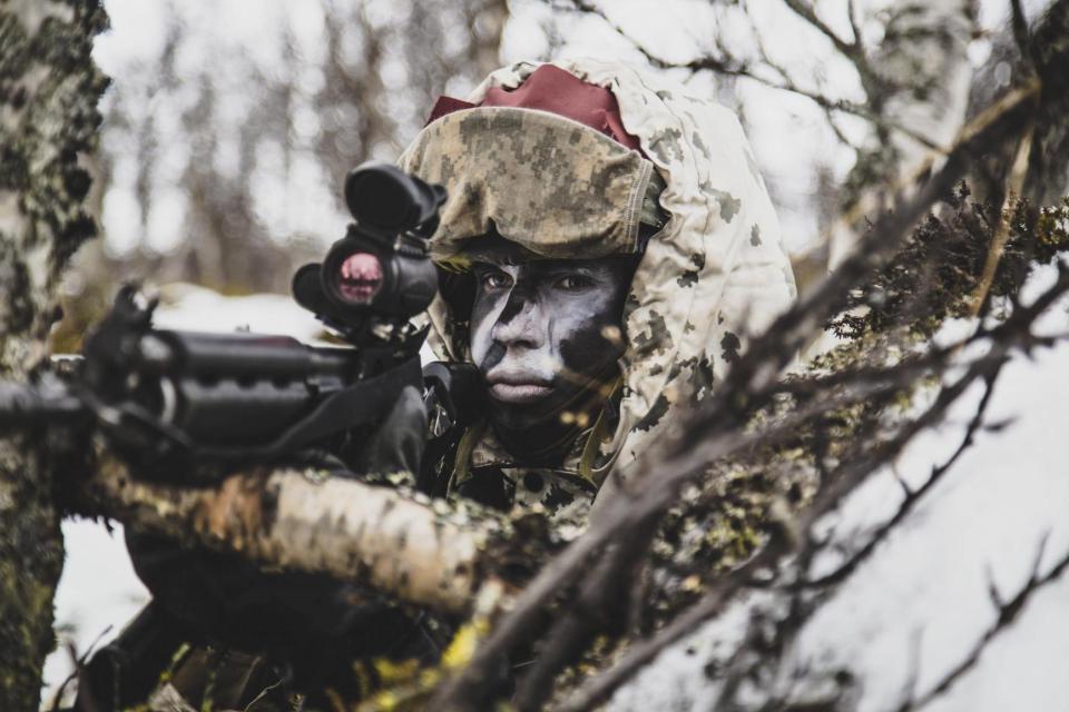 Finnish Jaeger Company soldier aiming a rifle during Trident Juncture 2018.