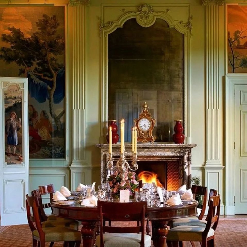 Dining room at Sandringham House with a fireplace and large mirror.