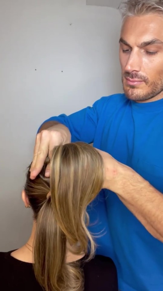A man styling a woman's ponytail.