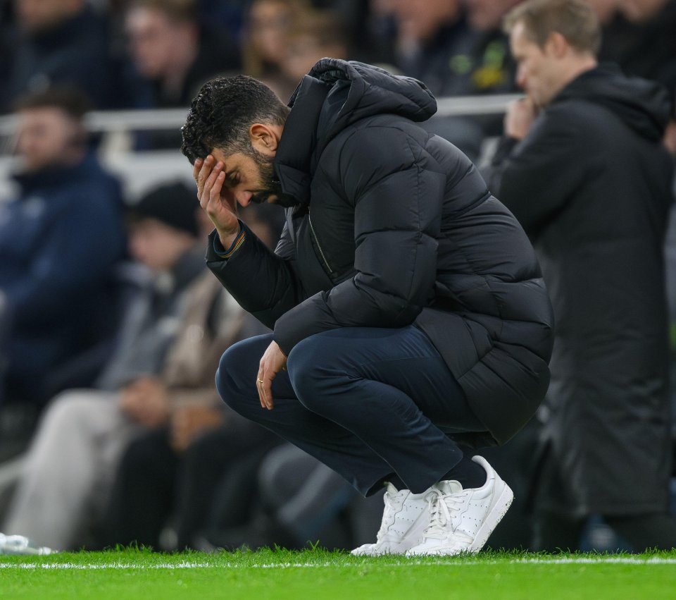 Ruben Amorim, Manchester United manager, sits on the field looking distraught.