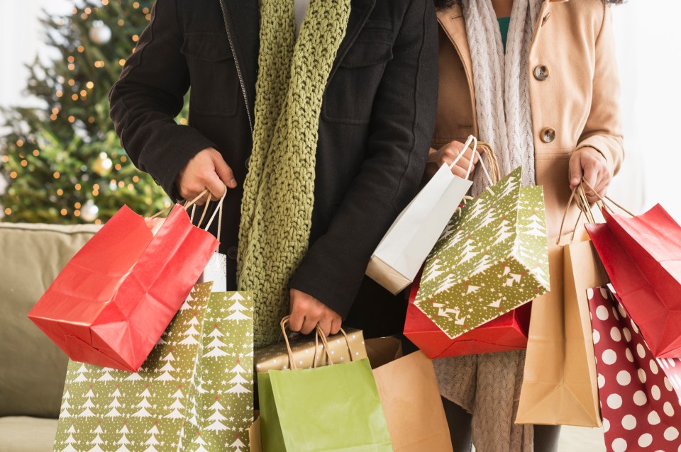 Couple holding Christmas shopping bags.