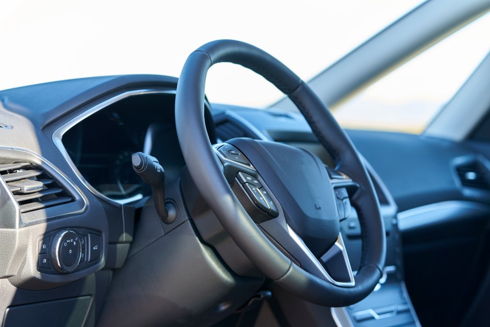 Close-up view of a car's steering wheel and control panel.