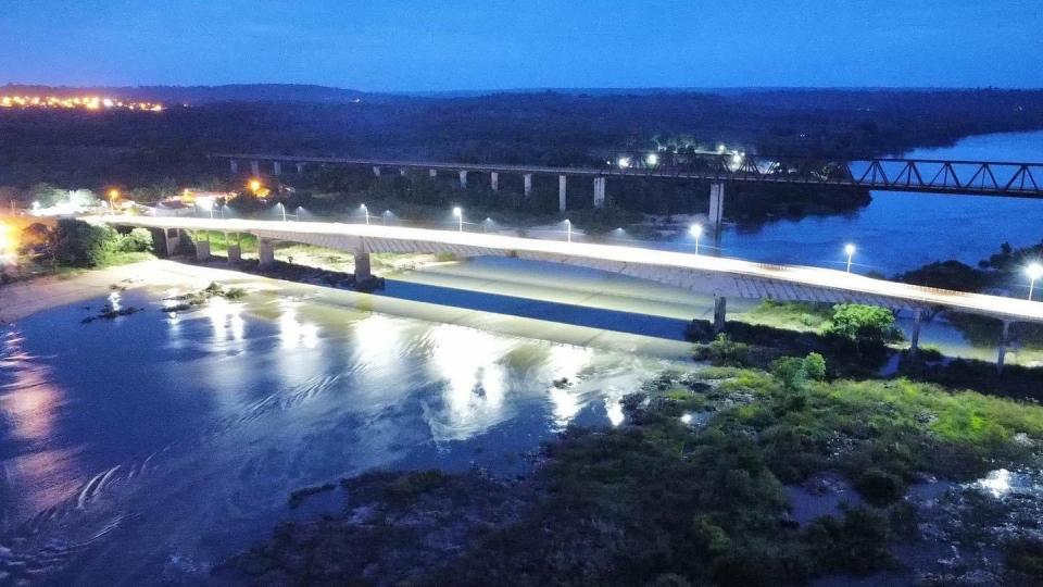 Nighttime aerial view of the illuminated Juscelino Kubitschek de Oliveira bridge in Tocantins, Brazil.