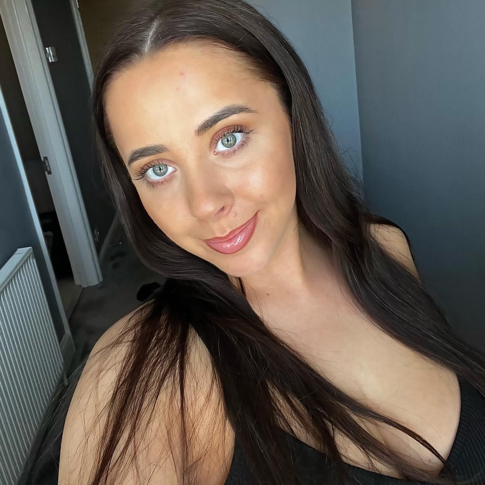 Close-up selfie of a woman with long brown hair.