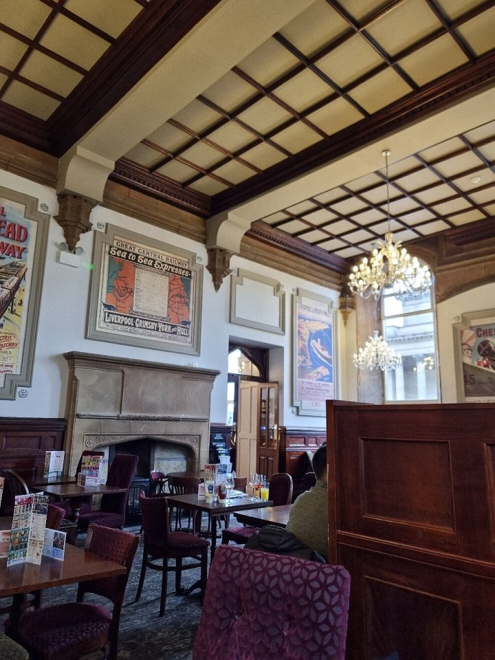 Interior of The North Western pub in Liverpool, showing dining area with vintage railway posters.