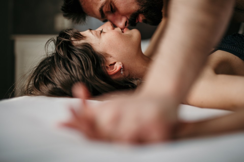Young couple kissing in bed.