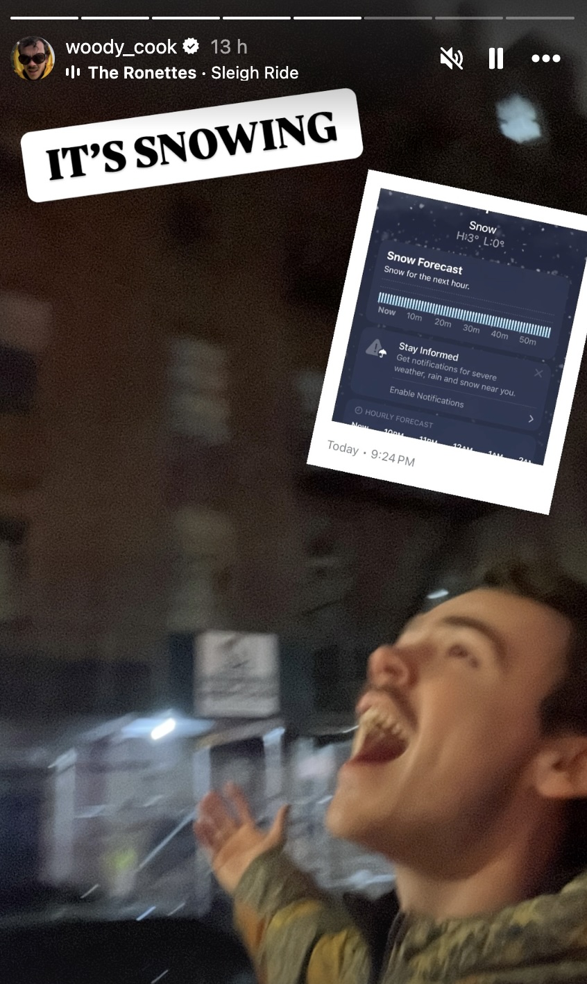 Person joyfully reacting to snowfall shown on a weather app.
