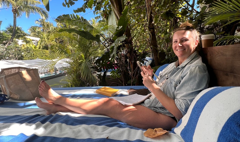 Woman relaxing outdoors, writing in a notebook.