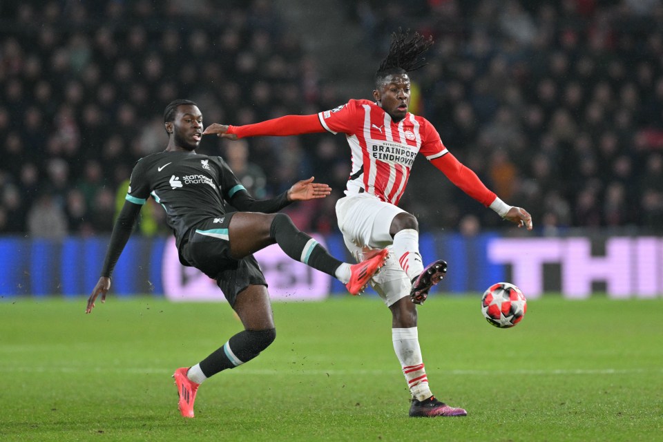Johan Bakayoko of PSV Eindhoven and a Liverpool defender vying for the ball during a soccer match.