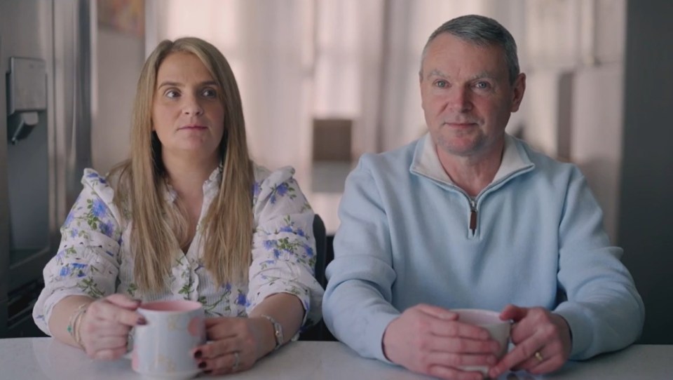 Sue and Noel Radford, parents of 22 children, sitting at a table, holding mugs.