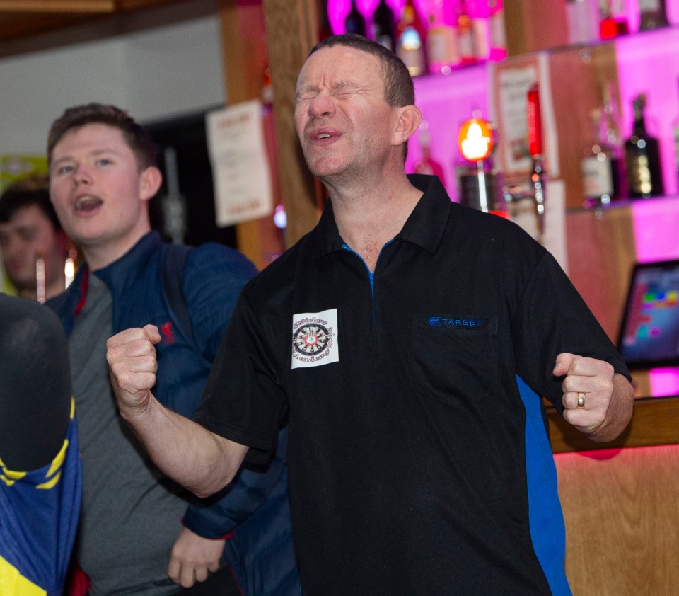 Karl Holden Littler, coach, reacts at a darts academy.