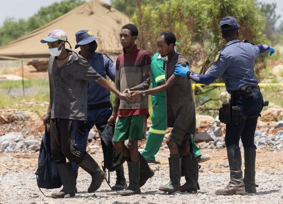 Rescued miners escorted by police.
