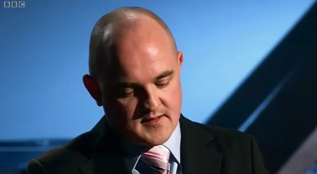 Man in suit looking down.