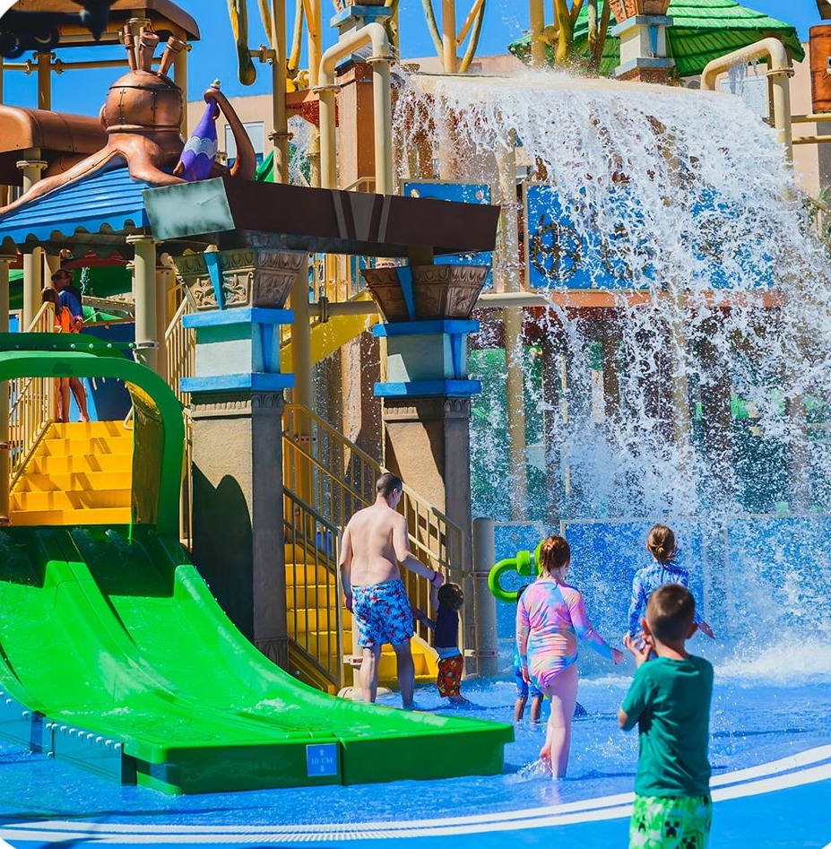 a group of children are playing in a water park