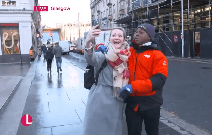 Woman and man taking a selfie on a Glasgow street.