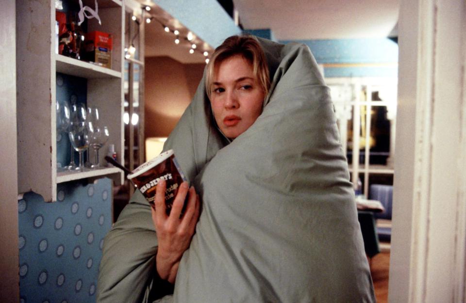 Renee Zellweger as Bridget Jones wrapped in a duvet, eating ice cream.