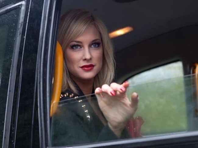 Woman with blonde hair sitting in a car.