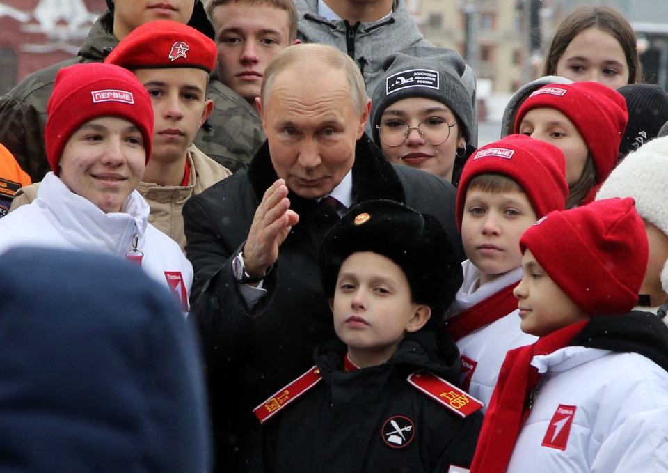 MOSCOW, RUSSIA - NOVEMBER 4: (RUSSIA OUT) Russian President Vladimir Putin poses with children of Russian officers, who are taking part in the military invasion of Ukraine and to participants of youth and student organizations, at the Red Square on November 4, 2024 in Moscow, Russia. Putin put flowers on the monument to Minin and Pozharsky, marking the National Unity Day. (Photo by Contributor/Getty Images)