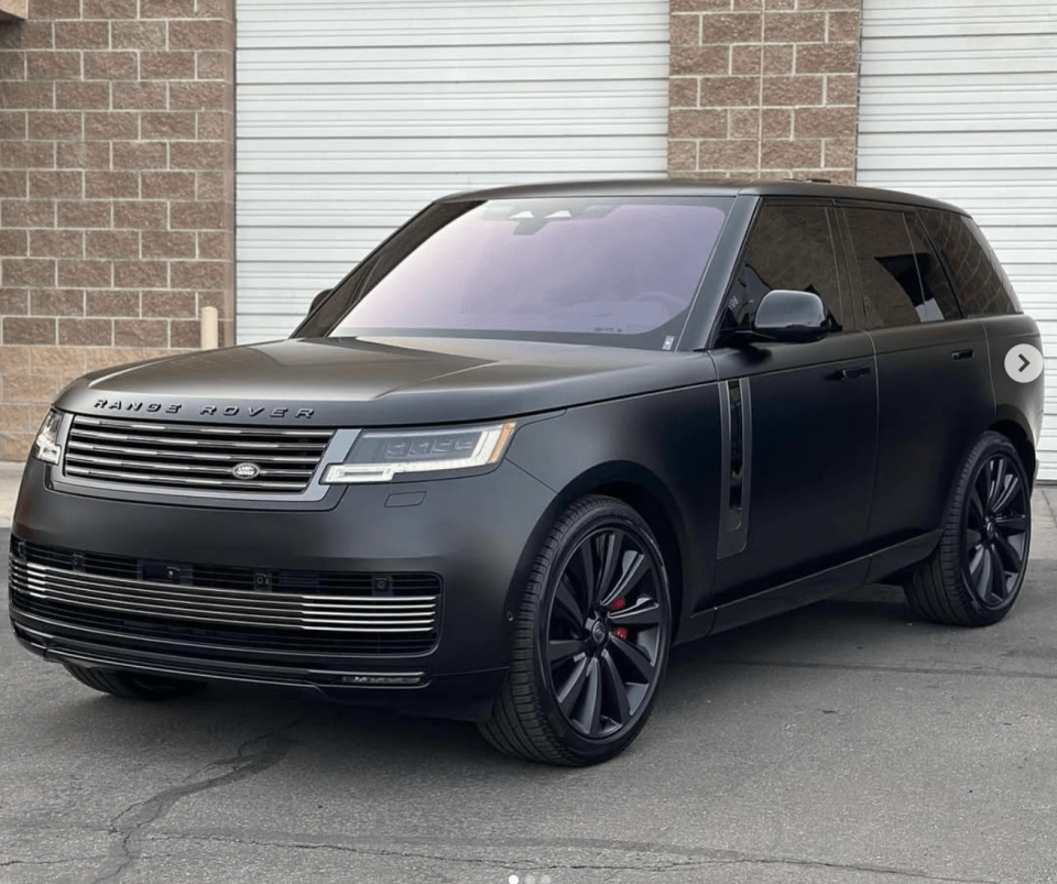 Black Range Rover parked in front of a garage.