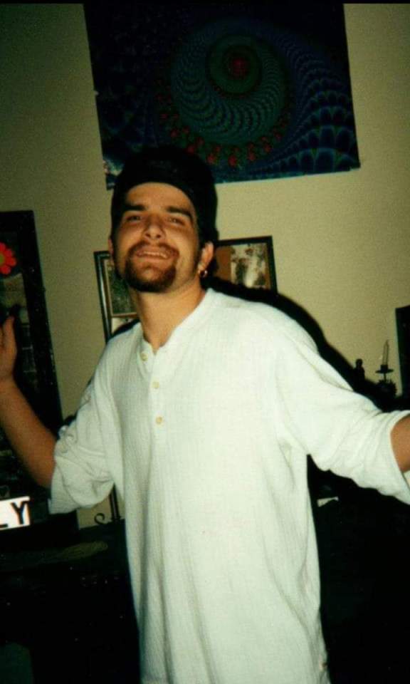 Photo of Steven smiling and wearing a white henley shirt.
