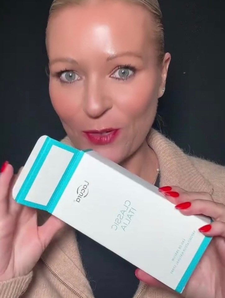 Woman holding up Aldi's Lacnia Classic perfume.