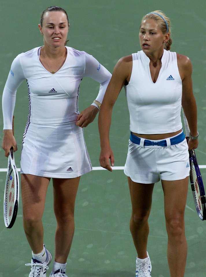 Martina Hingis and Anna Kournikova discussing tactics on a tennis court.