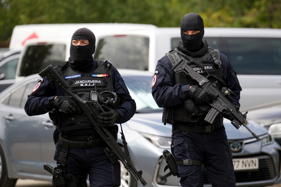 Two armed Romanian gendarmes in balaclavas.