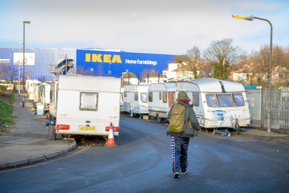 Person walking past caravans parked near an IKEA store.