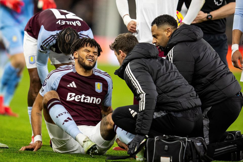 Aston Villa player receiving medical attention on the field.
