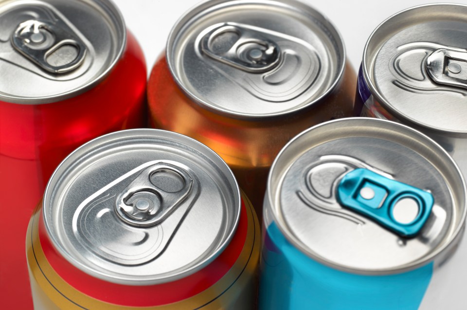 Close-up of five soda cans.