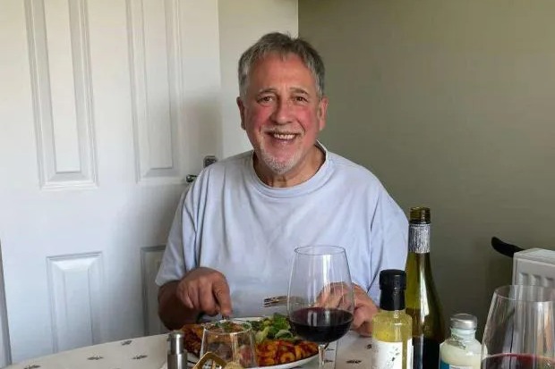 Man sitting at a table eating a meal.