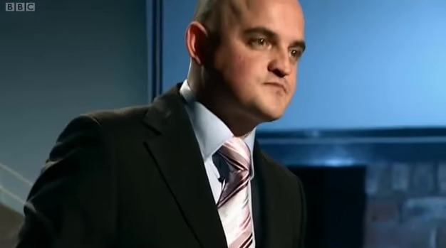 Man in suit speaking.