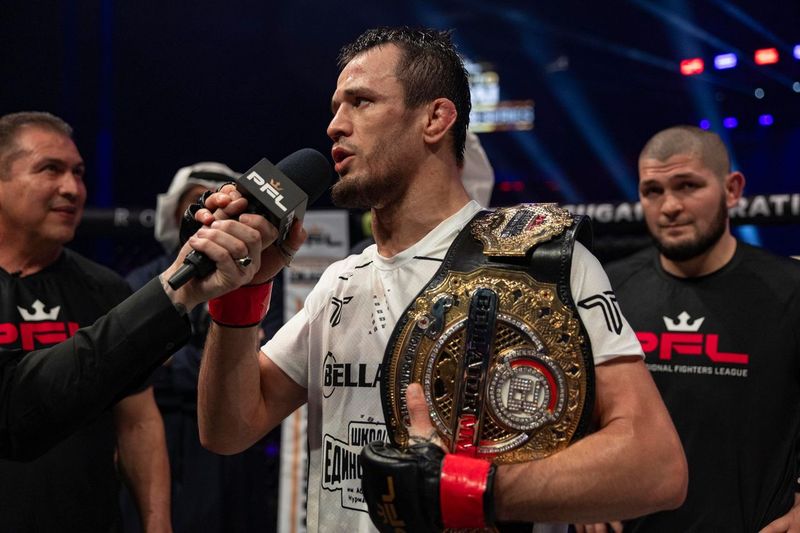A fighter holding a championship belt and being interviewed.