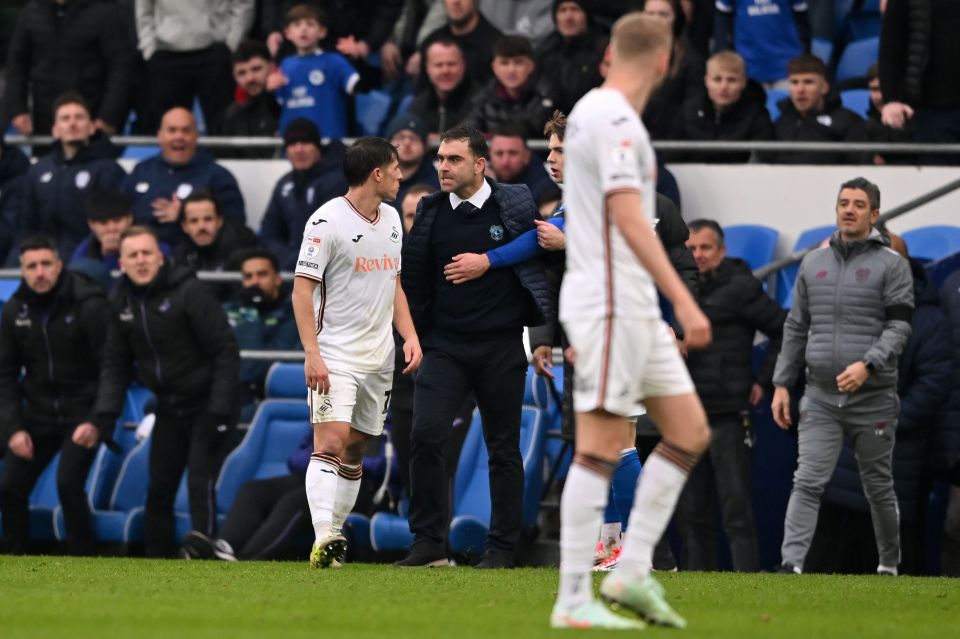 Cardiff City interim manager Omer Riza being restrained by players after a touchline altercation.
