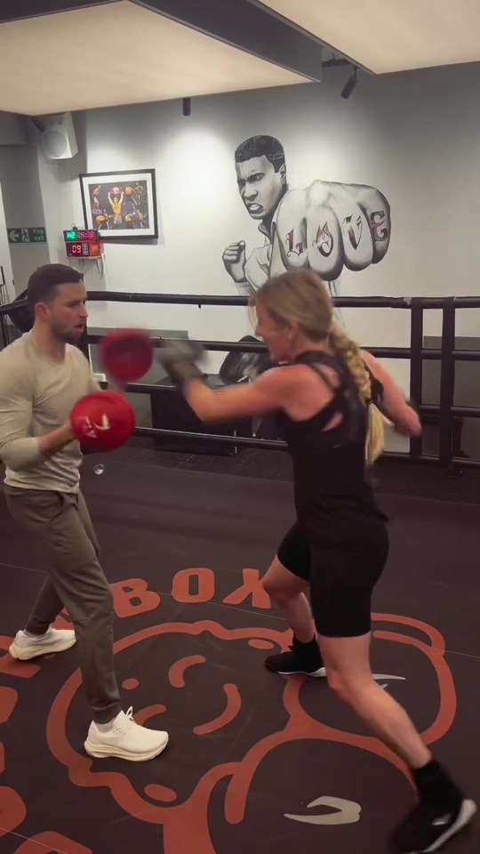 Ellie Goulding boxing with a trainer.