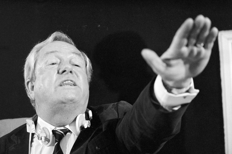 Jean-Marie Le Pen gesturing at a press conference.