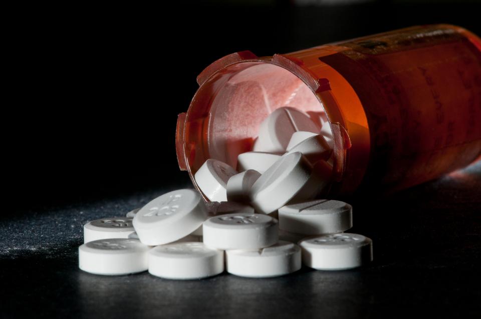 Oxycodone pills spilled from a prescription bottle.
