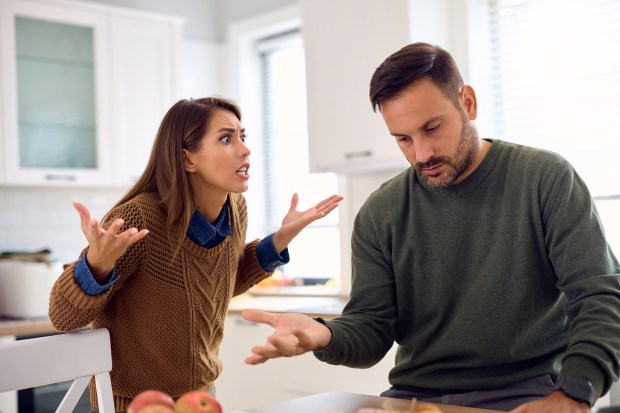 A couple arguing in their kitchen.
